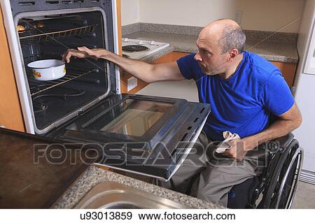 Stock Photo - Man with deformed hands in the kitchen. Fotosearch