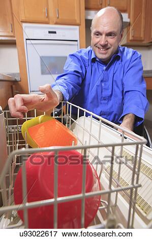 Stock Photo - Man with deformed hands in the kitchen. Fotosearch