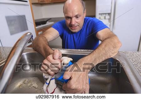 Stock Photograph - Man with deformed hands in the kitchen. Fotosearch