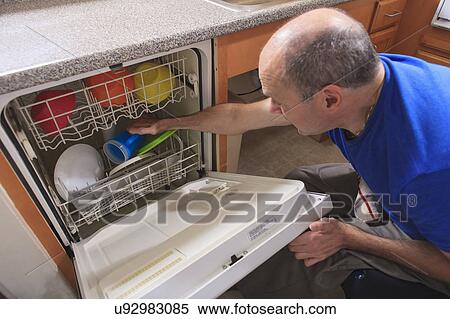 Stock Photography - Man with deformed hands in the kitchen. Fotosearch