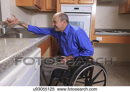 Stock Photography - Man with deformed hands in the kitchen. Fotosearch
