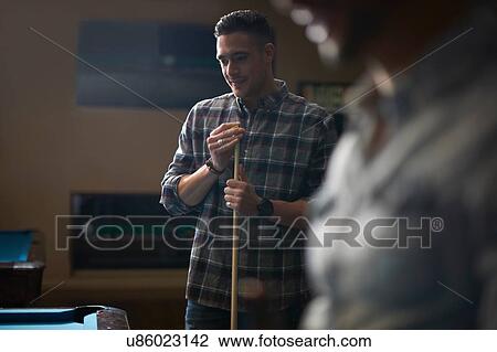 Man with pool cue standing at pool table View Large Photo Image Stock Image - Man with pool cue standing at pool table. Fotosearch