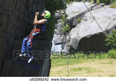 Stock Image - Man with spinal cord injury rock climbing. Fotosearch