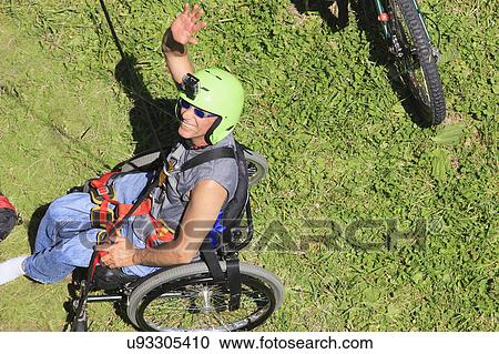 Stock Image - Man with spinal cord injury rock climbing. Fotosearch