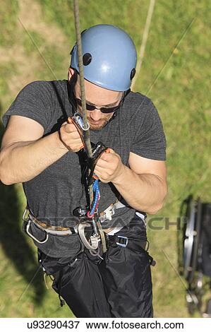 Stock Photo - Man with spinal cord injury rock climbing. Fotosearch