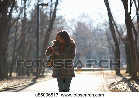 Stock Photo - Mature female tourist strolling in park, Tokyo, Japan. Fotosearch