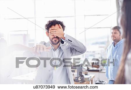 Stock Photo - Mature man in team building task, holding hands covering eyes. Fotosearch