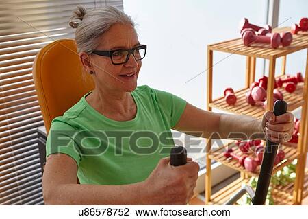 Mature woman exercising on gym exercise machine View Large Photo Image Stock Image - Mature woman exercising on gym exercise machine. Fotosearch