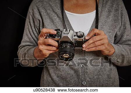 Mature woman holding camera View Large Photo Image Stock Photo - Mature woman holding camera. Fotosearch