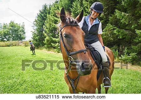 Mature woman on horseback wearing riding hat and boots looking at horse smiling View Large Photo Image Stock Photography - Mature woman on horseback wearing riding hat and boots looking at horse smiling. Fotosearch