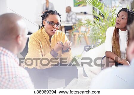 Picture - Mature woman talking to colleagues, hand gestures. Fotosearch