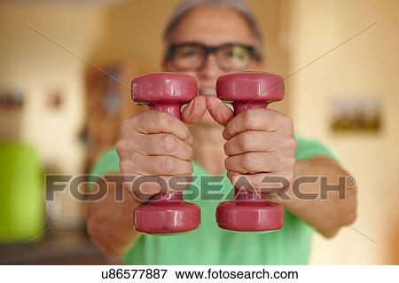 Mature woman weight lifting dumbbells at home View Large Photo Image Stock Photo - Mature woman weight lifting dumbbells at home. Fotosearch