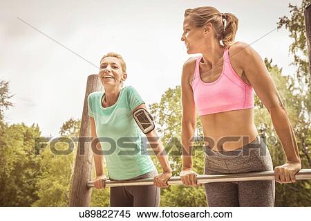 Mature women in park doing push ups on metal bar smiling View Large Photo Image Stock Photography - Mature women in park doing push ups on metal bar smiling. Fotosearch