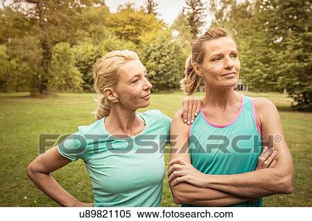 Stock Photography - Mature women in park wearing sports clothing arms crossed looking away. Fotosearch