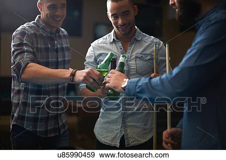 Men toasting with beer at pool club View Large Photo Image Stock Photo - Men toasting with beer at pool club. Fotosearch