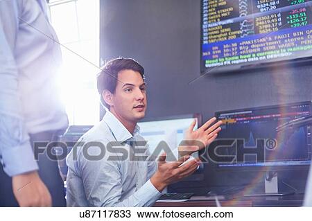 Stock Image - Mid adult business man in office having discussion, hand gestures. Fotosearch