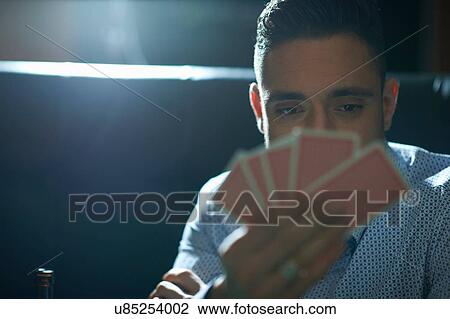 Mid adult man with hand of playing cards playing cards in traditional UK pub View Large Photo Image Stock Image - Mid adult man with hand of playing cards playing cards in traditional UK pub. Fotosearch