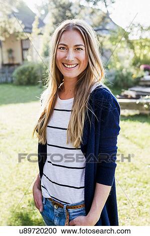 Stock Image - Mid adult woman smiling towards camera, portrait. Fotosearch