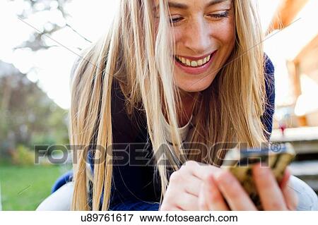 Stock Photo - Mid adult woman using smartphone. Fotosearch