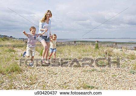 Stock Photo - Mother and children on beach. Fotosearch