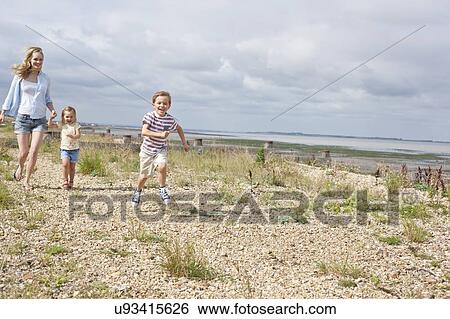 Stock Photograph - Mother and children on beach. Fotosearch