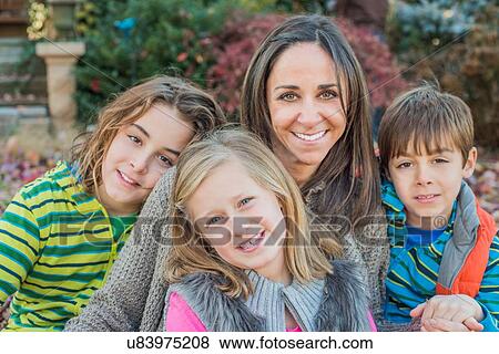 Mother and children smiling in garden View Large Photo Image Stock Photo - Mother and children smiling in garden. Fotosearch