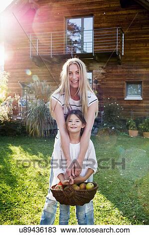 Mother and daughter holding basket of apples View Large Photo Image Stock Image - Mother and daughter holding basket of apples. Fotosearch