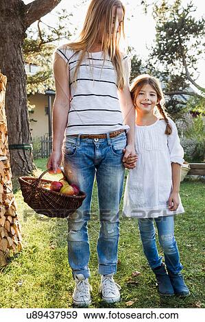 Mother and daughter holding hands, mother holding basket of apples View Large Photo Image Stock Photo - Mother and daughter holding hands, mother holding basket of apples. Fotosearch