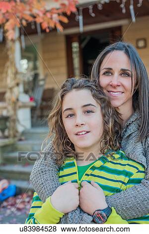 Mother and son smiling in front of house View Large Photo Image Stock Photo - Mother and son smiling in front of house. Fotosearch