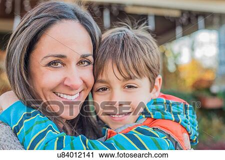 Stock Image - Mother hugging son. Fotosearch