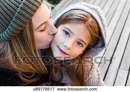Mother kissing daughter on cheek, high angle portrait View Large Photo Image Stock Photo - Mother kissing daughter on cheek, high angle portrait. Fotosearch