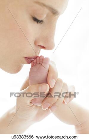 Mother kissing newborn's foot View Large Photo Image Stock Photograph - Mother kissing newborn's foot. Fotosearch