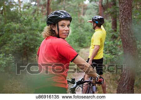 Mountain biking couple biking on forest trail View Large Photo Image Stock Photography - Mountain biking couple biking on forest trail. Fotosearch