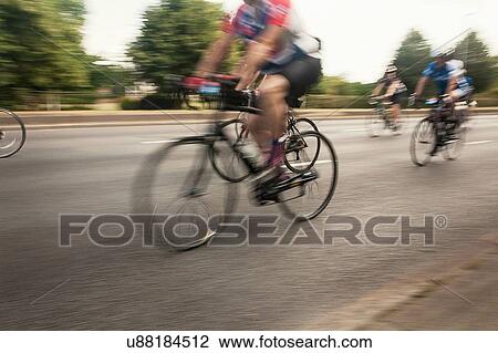Neck down view of three racing cyclists speeding on urban road in racing cycle race View Large Photo Image Stock Image - Neck down view of three racing cyclists speeding on urban road in racing cycle race. Fotosearch