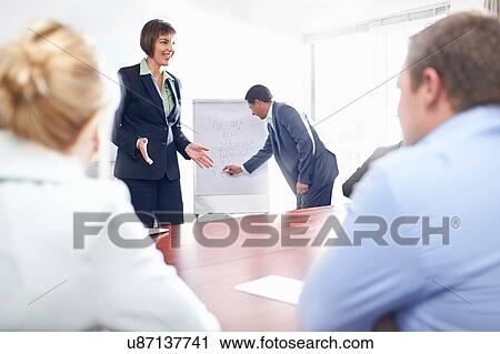 Over shoulder view of colleagues in conference room watching presentation View Large Photo Image Stock Image - Over shoulder view of colleagues in conference room watching presentation. Fotosearch