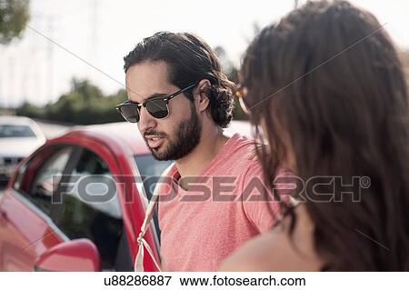 Stock Photo - Over the shoulder view of young couple at roadside, Los Angeles, California, USA. Fotosearch