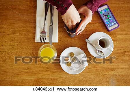 Overhead cropped view of woman removing euro coins from purse in restaurant View Large Photo Image Stock Image - Overhead cropped view of woman removing euro coins from purse in restaurant. Fotosearch