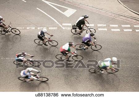 Overhead view of eight cyclists speeding on urban road in racing cycle race View Large Photo Image Stock Photograph - Overhead view of eight cyclists speeding on urban road in racing cycle race. Fotosearch