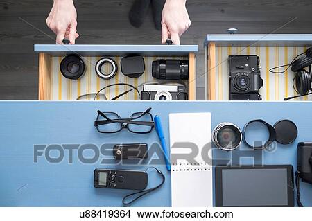 Overhead view of female photographers hands opening desk drawer in studio View Large Photo Image Picture - Overhead view of female photographers hands opening desk drawer in studio. Fotosearch