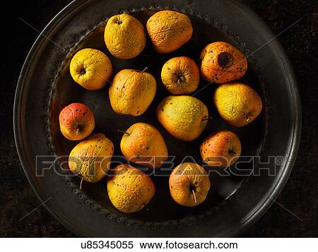 Stock Photography - Overhead view of old red and golden apples on pewter plate. Fotosearch