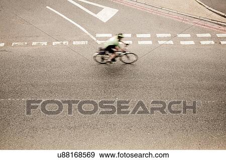 Stock Photo - Overhead view of racing cyclist speeding on urban road in racing cycle race. Fotosearch