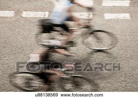 Stock Photo - Overhead view of two cyclists speeding on urban road in racing cycle race. Fotosearch