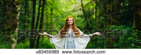 Panoramic image of young woman meditating with arms open in forest View Large Photo Image Stock Photography - Panoramic image of young woman meditating with arms open in forest. Fotosearch