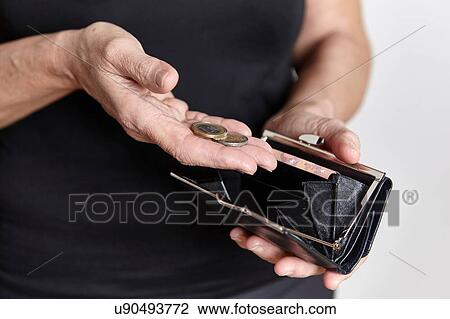 Stock Image - Person looking for loose change in coin purse. Fotosearch