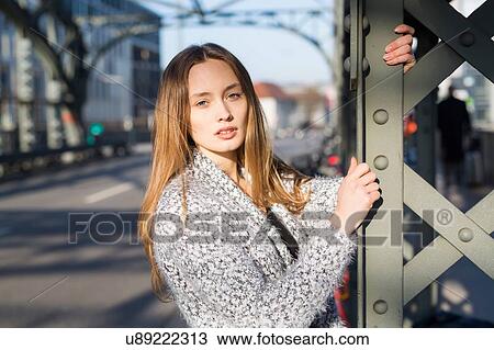 Stock Image - Portrait of beautiful mid adult woman on city bridge. Fotosearch