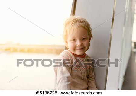 Portrait of cute girl sitting at window seat View Large Photo Image Stock Photo - Portrait of cute girl sitting at window seat. Fotosearch