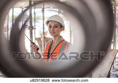 Stock Photo - Portrait of female builder on construction site. Fotosearch