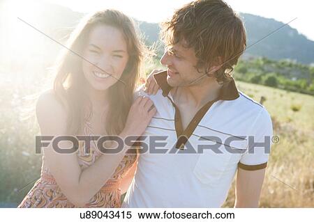 Stock Photography - Portrait of happy young couple in meadow, Majorca, Spain. Fotosearch