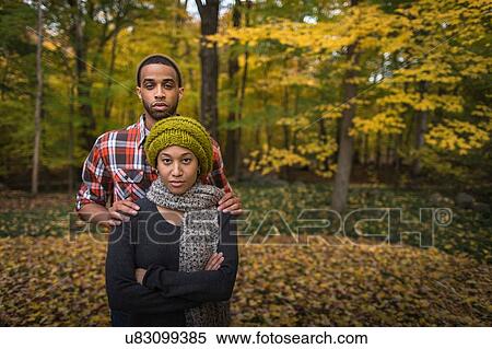 Stock Photography - Portrait of mid adult couple standing in autumn forest. Fotosearch