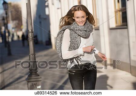 Portrait of mid adult woman running along city street View Large Photo Image Stock Photograph - Portrait of mid adult woman running along city street. Fotosearch